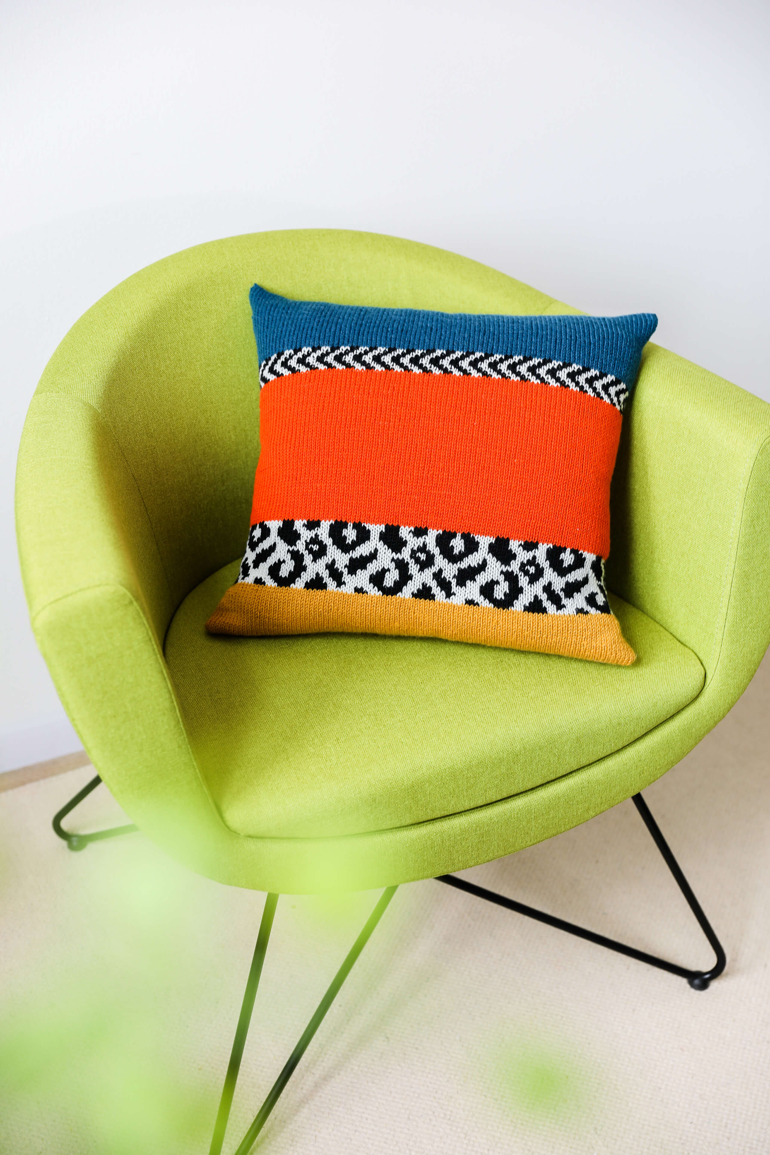 grüner Stuhl mit buntem Kissen und Leoparden Applikation