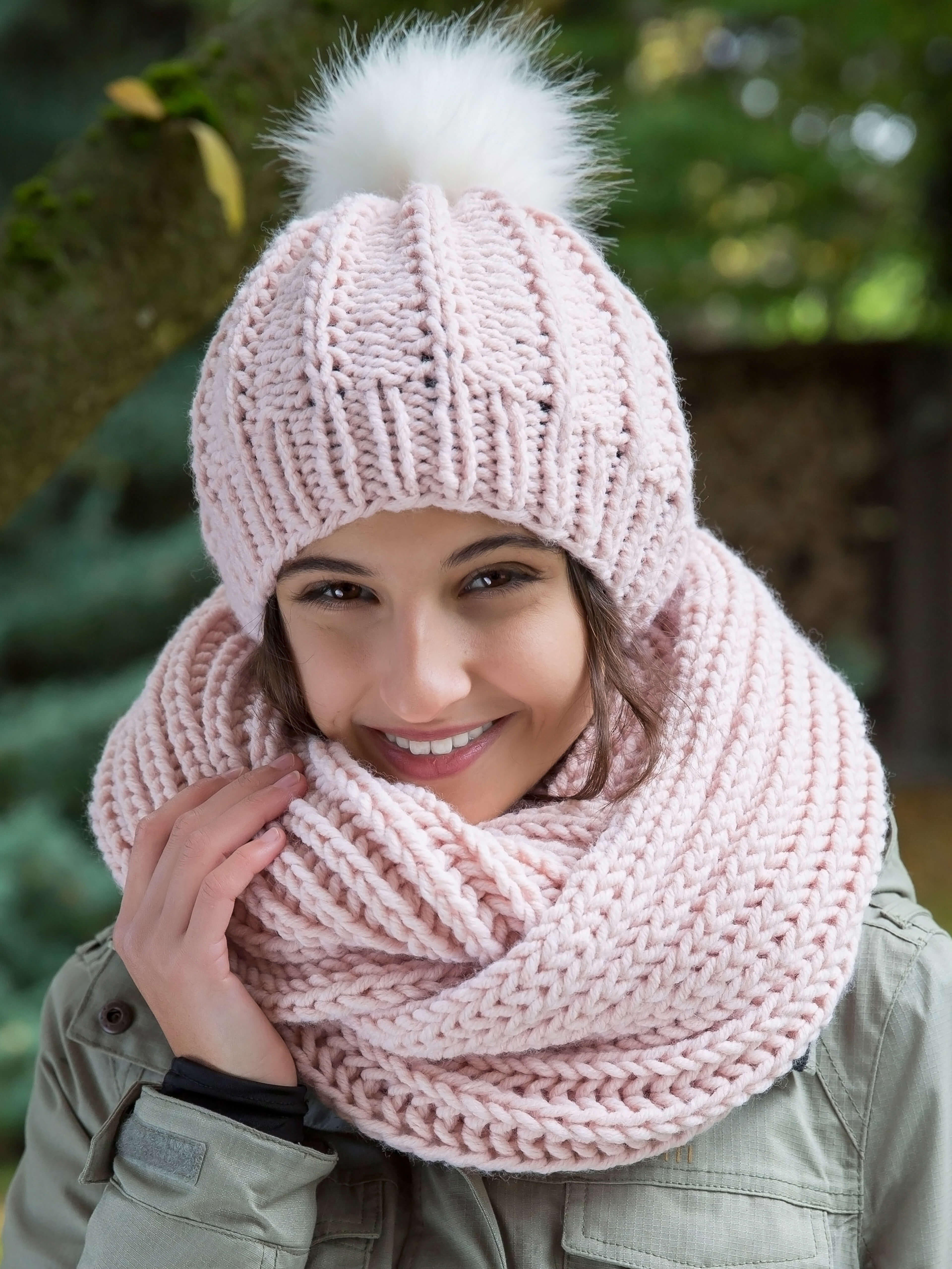 winterlich gekleidete Frau mit rosa Mütze und Loop