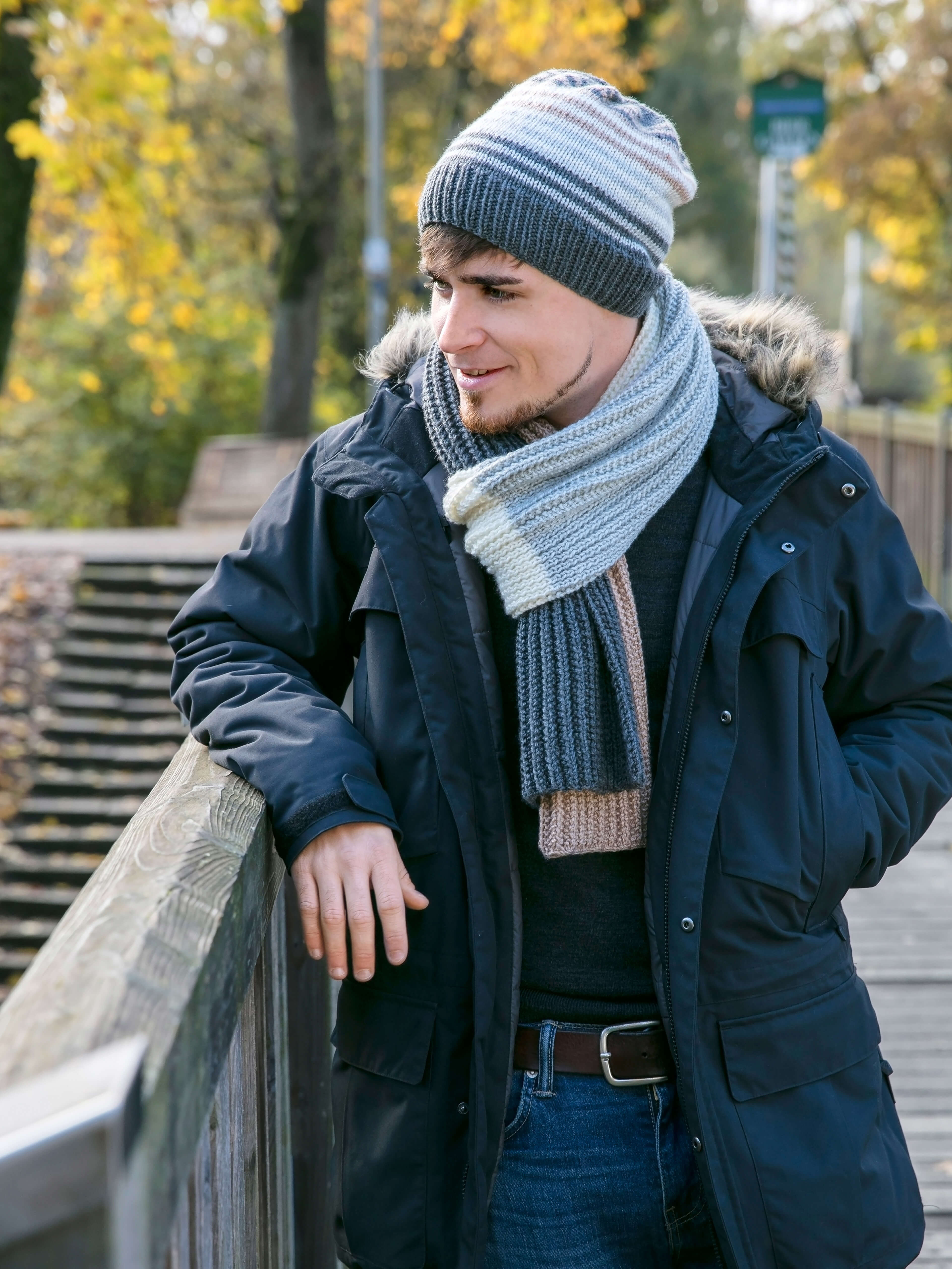 junger Mann mit Mütze und Schal im Herbst