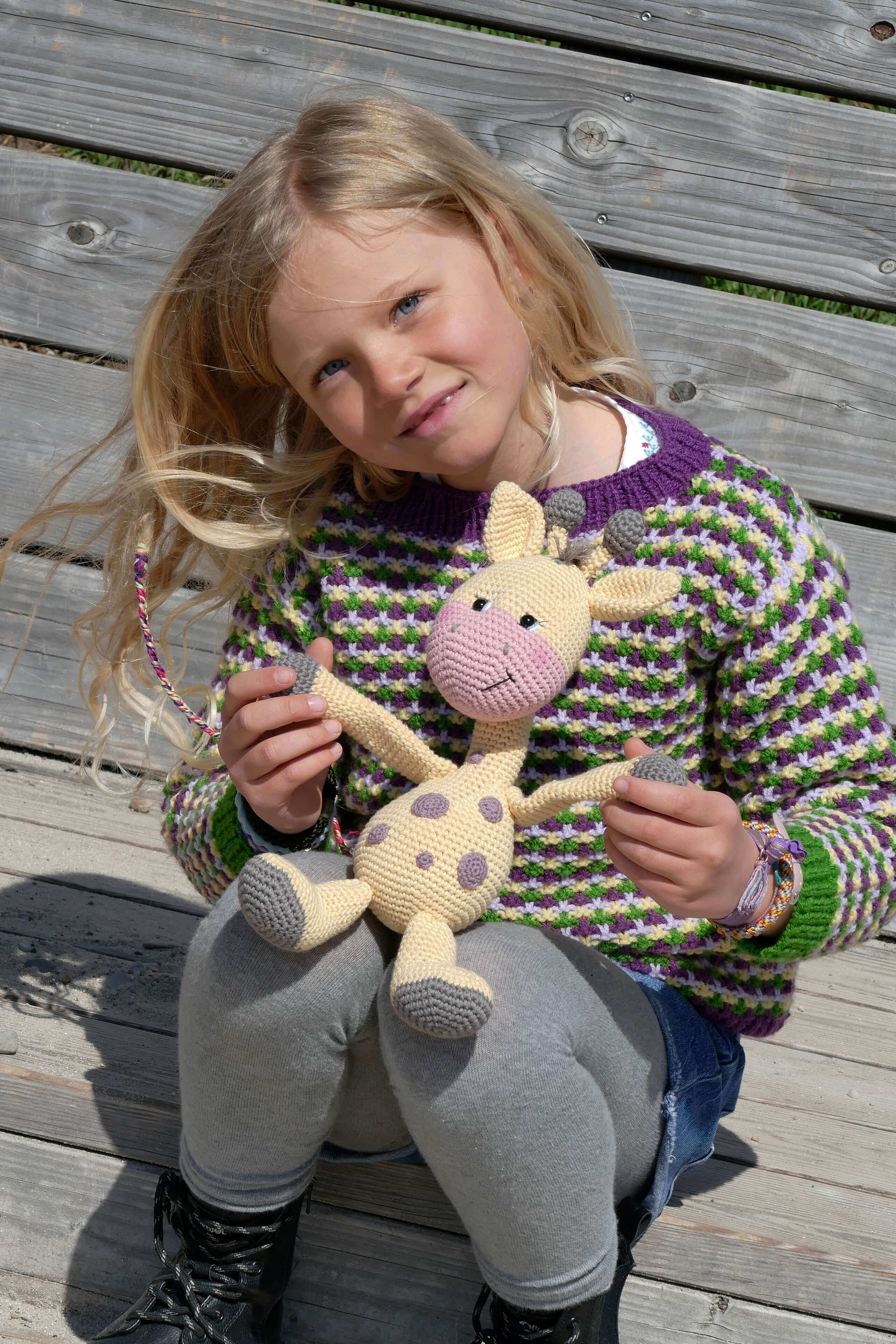 kleines Mädchen hält selbstgemachte Giraffe in der Hand 