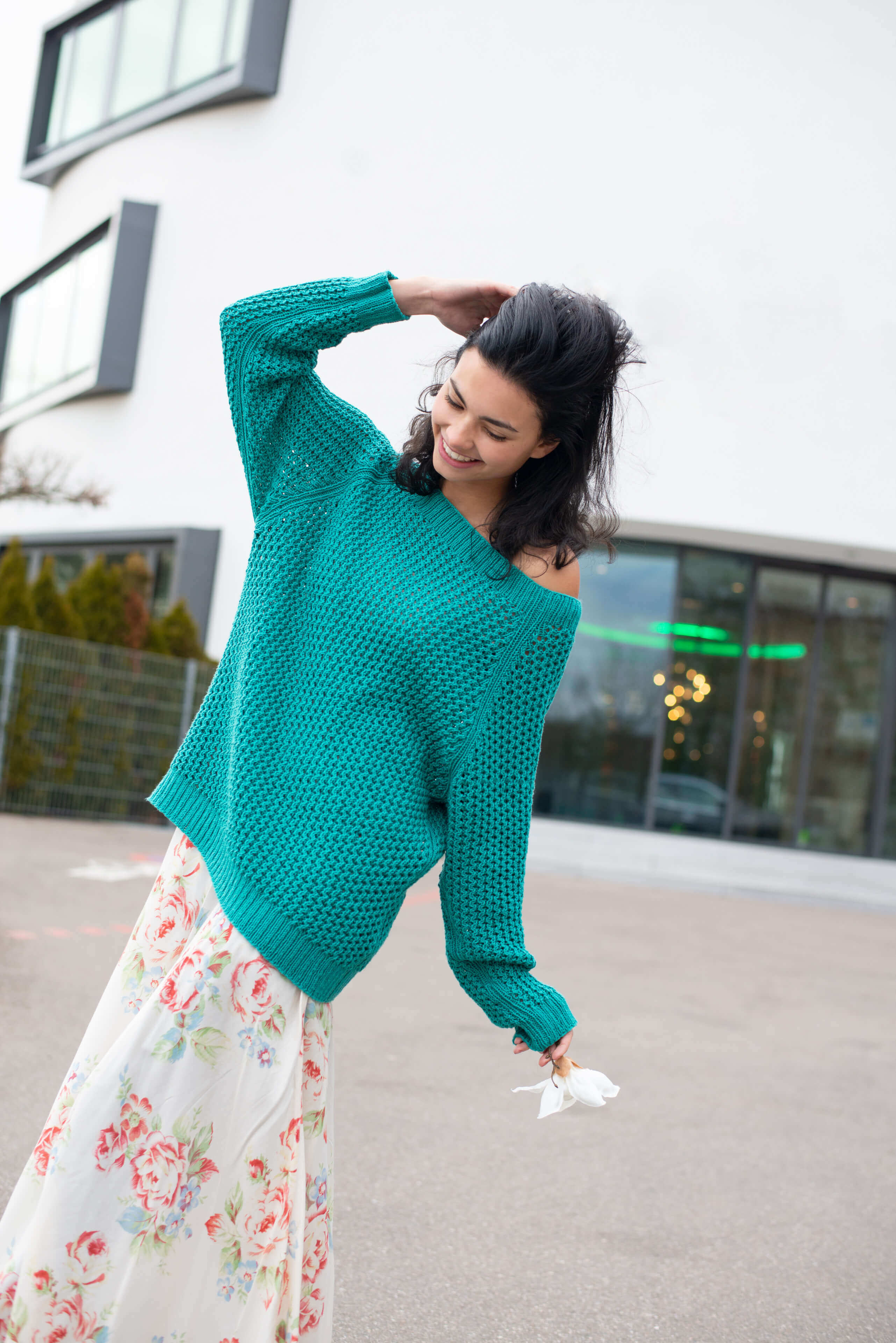 junge tanzende Frau mit selbstgestricktem türkisen Pullover