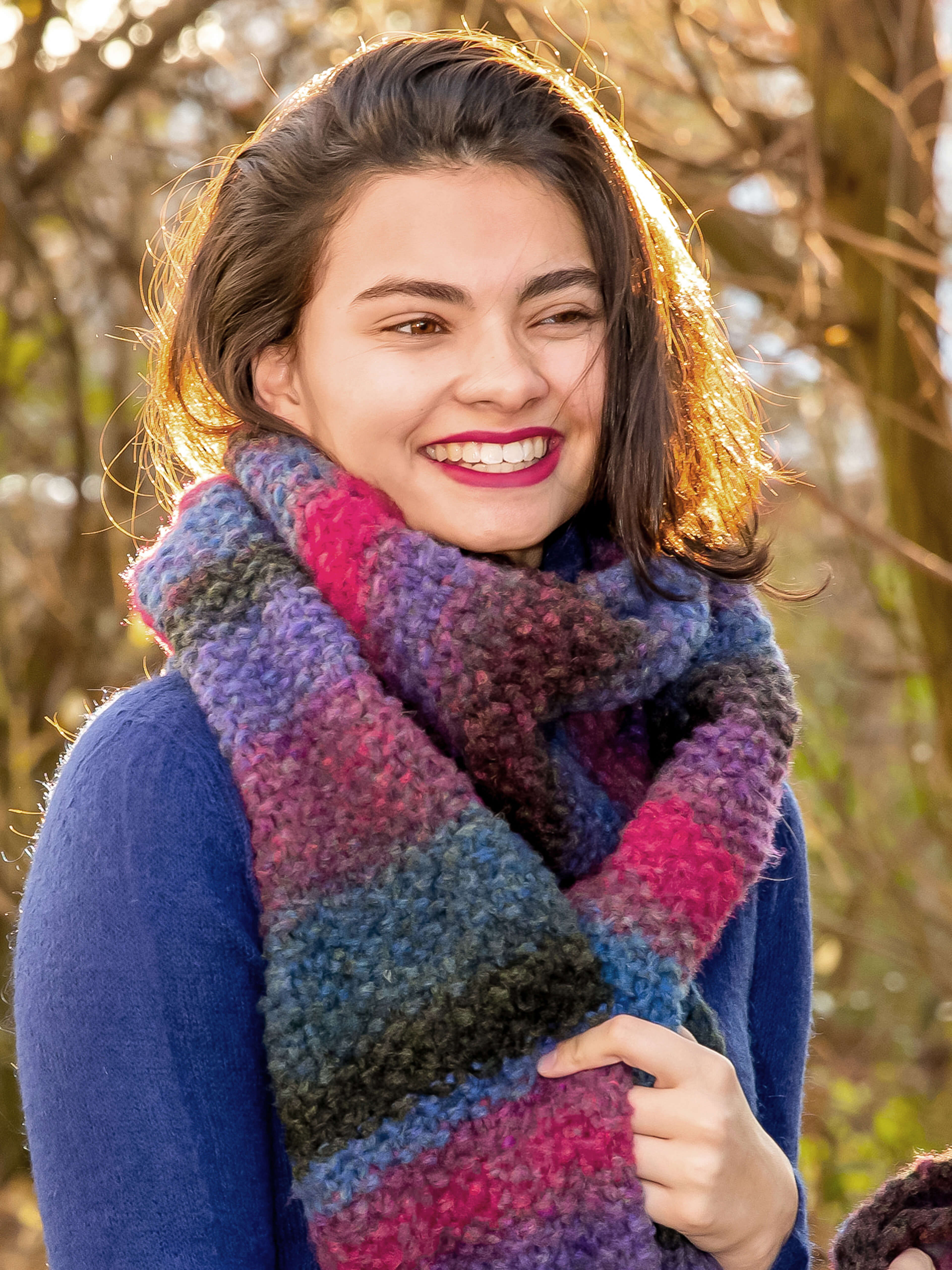 lachende Frau mit türkis-pinkem Schal  im Herbst