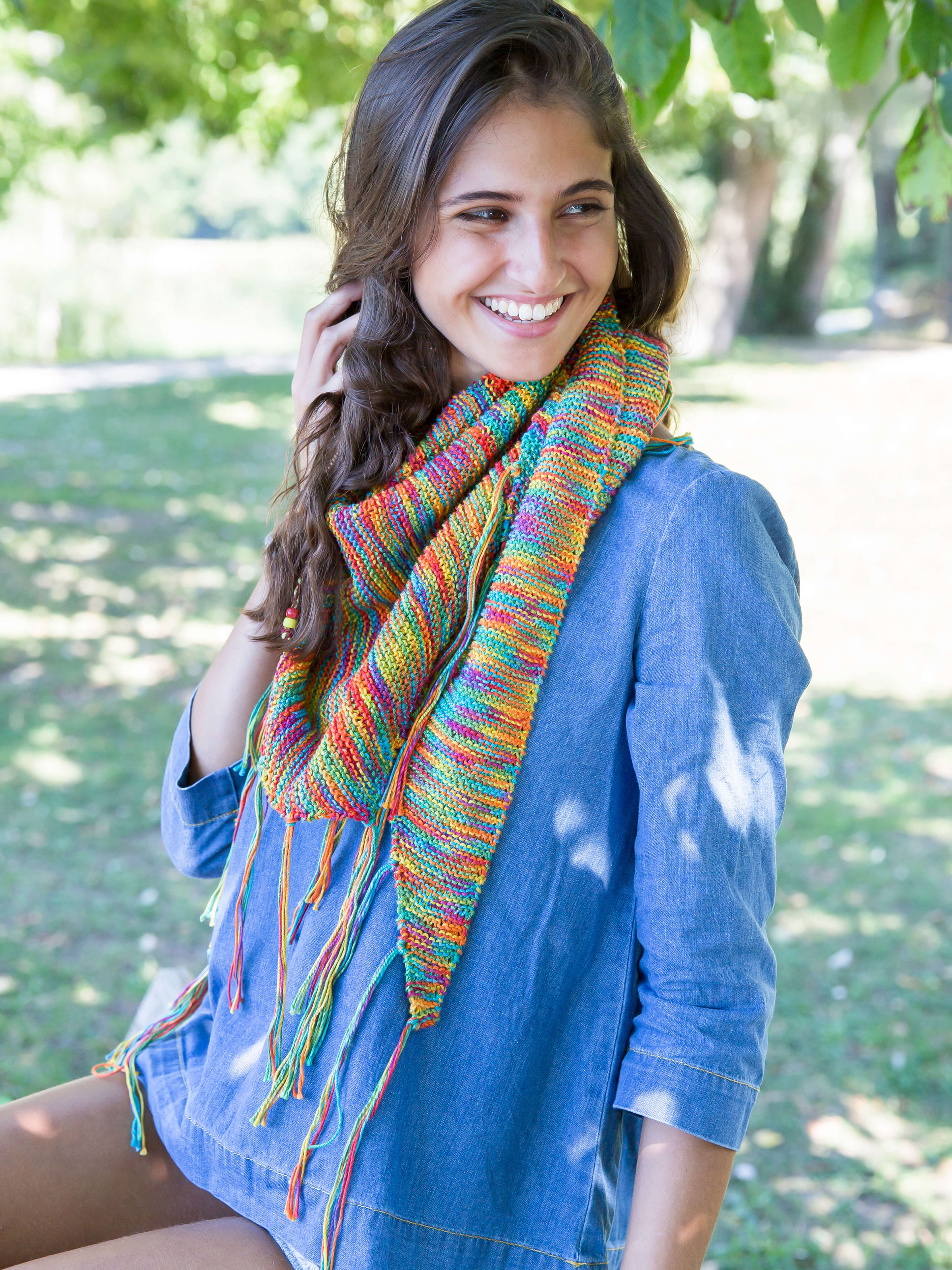Frau mit einem gestricktem bunten Schal mit Fransen aus  Cotton Quick print Wolle von Gründl 